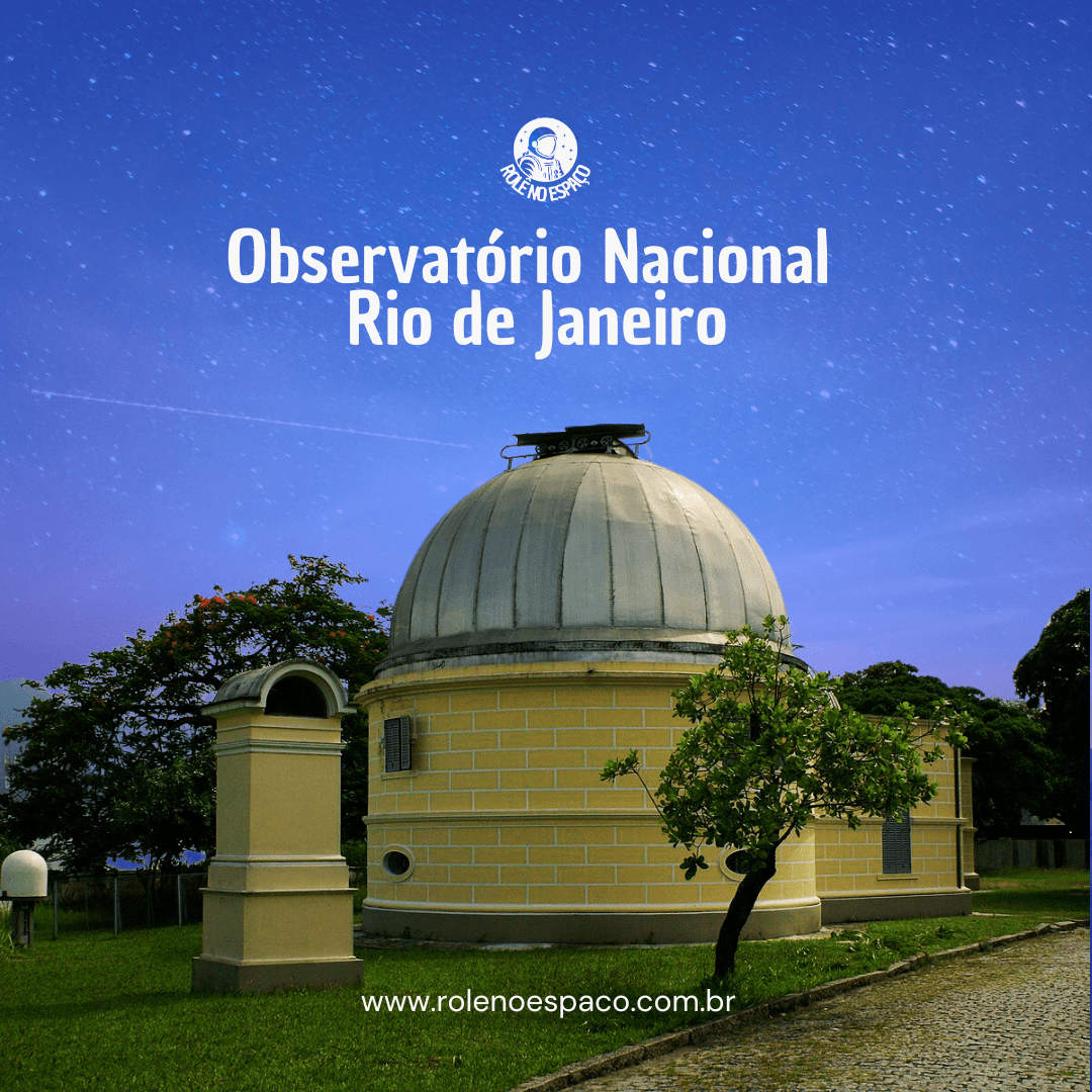 "Imagem do Observatório Nacional no Rio de Janeiro, com a cúpula de avistamento visível e a estrutura de tijolos amarelos. A cúpula branca destaca-se contra o céu estrelado. O edifício está cercado por árvores e uma grama verde, criando um cenário tranquilo e perfeito para a observação astronômica