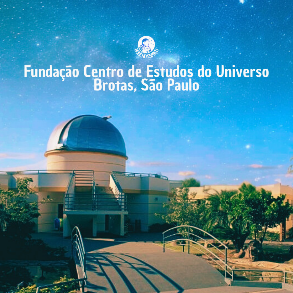 A Fundação Centro de Estudos do Universo, localizada em Brotas, São Paulo, sob um céu estrelado. A cúpula metálica de observação é visível, destacando-se à frente do prédio. Uma ponte de acesso leva até o observatório, enquanto algumas árvores cercam o local, criando uma atmosfera tranquila e propícia para o estudo do cosmos. Este é um dos principais observatórios astronômicos do Brasil, dedicado à pesquisa e à educação astronômica.