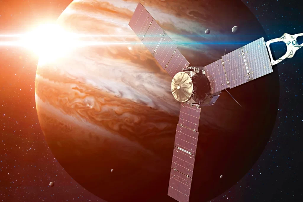Ilustração da sonda Juno da NASA se aproximando de Júpiter, com o gigante gasoso ao fundo durante a missão científica no sistema joviano.