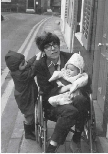Stephen Hawking jovem, com sinais iniciais da esclerose lateral amiotrófica (ELA), segurando sua filha Lucy no colo, enquanto seu filho Robert está ao lado, apoiado na cadeira. Eles estão juntos, sorrindo e aproveitando o momento familiar.