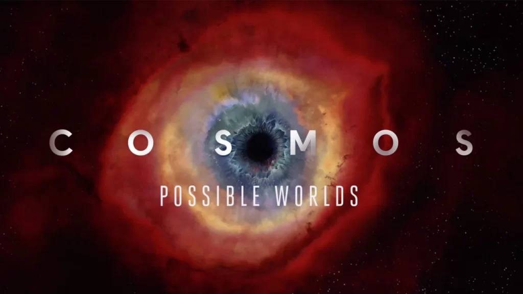 a icônica capa do programa de TV Cosmos, A imagem exibe o Olho de Hélice (Helix Nebula), uma nebulosa planetária que se assemelha a um olho cósmico, com a palavra "COSMOS" destacada no centro.