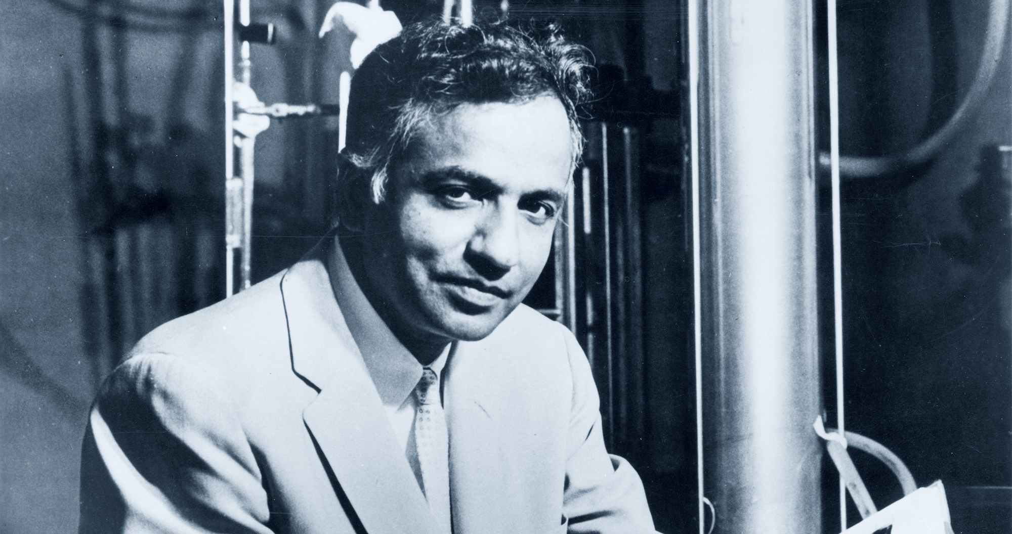 Subrahmanyan Chandrasekhar em uma foto de perfil, vestindo um terno social escuro. Seu cabelo está bem penteado, refletindo sua postura elegante e acadêmica
