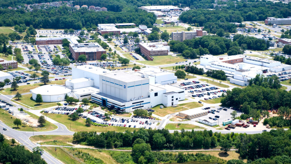  Goddard Space Flight Center, localizado em Greenbelt, Maryland. A vista mostra as instalações da NASA, com diversos prédios e áreas de pesquisa, representando o papel do centro na exploração espacial e nas missões científicas da agência.