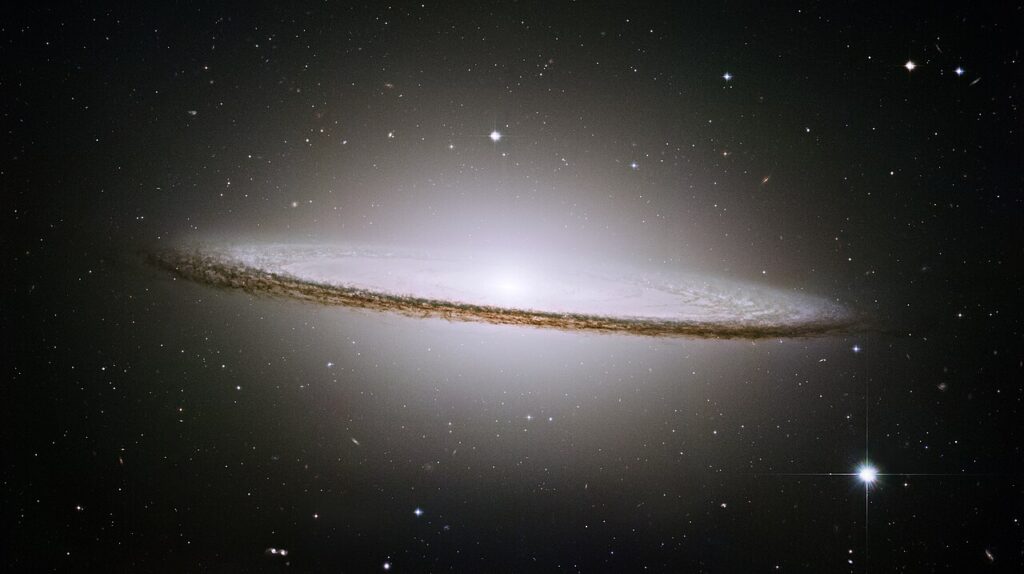 A Galáxia do Sombrero Imagem nítida da Galáxia do Sombrero, com seu núcleo brilhante e disco galáctico cercado por poeira escura, registrada pelo Hubble em contraste com o fundo estrelado do universo.