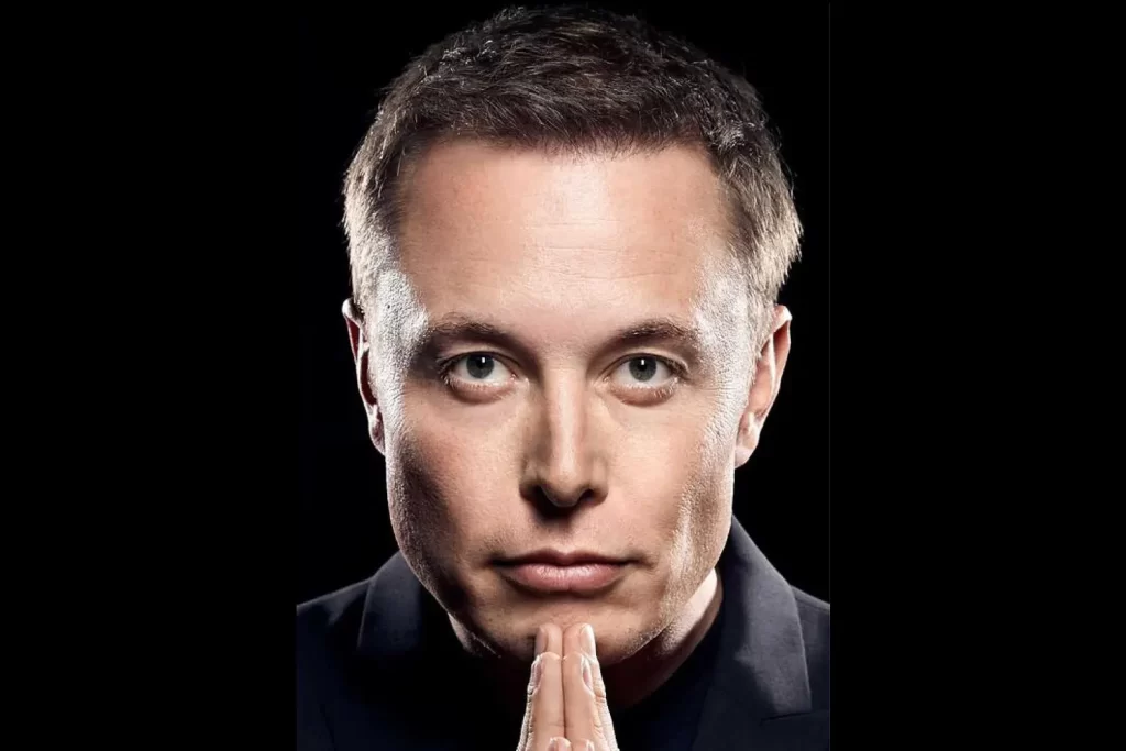 Elon Musk de terno em um evento, segurando um copo de café e com expressão pensativa, como se refletisse sobre algo importante.