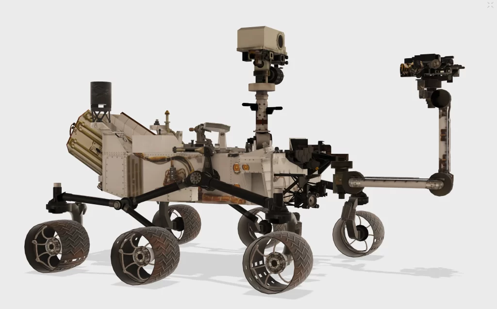 Modelo 3D detalhado do rover Curiosity da NASA, com aparência robusta semelhante a um SUV compacto. Mede cerca de 3 metros de comprimento, 2,7 metros de largura e 2,1 metros de altura (sem incluir o braço robótico), com o braço estendido alcançando aproximadamente 2,2 metros. O corpo principal exibe instrumentos científicos, um laboratório geológico interno, múltiplas câmeras no mastro, rodas articuladas com suspensão rocker-bogie para terrenos acidentados e um laser para vaporização de rochas. O modelo reflete sua massa de 899 kg na Terra (337 kg em Marte) e destaca suas funcionalidades para exploração planetária em alta resolução.