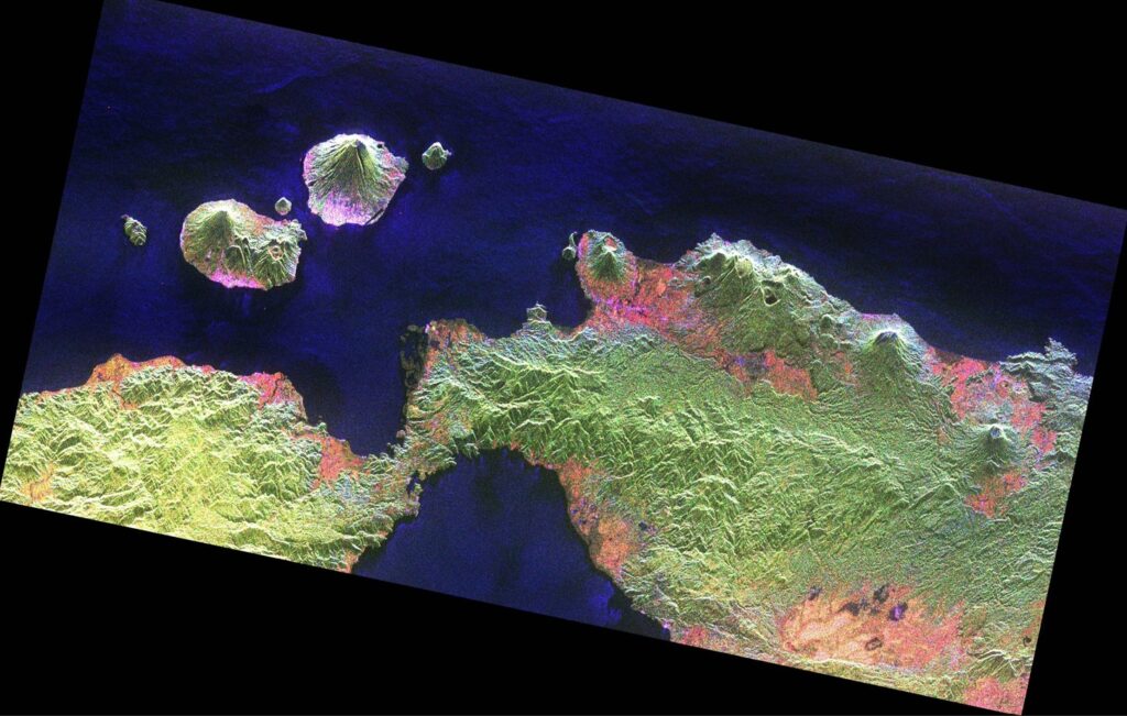 Imagem de radar capturada pelo satélite Biomass da ESA mostrando florestas tropicais nas ilhas da Indonésia, incluindo a floresta de Halmahera em terreno montanhoso de origem vulcânica. Destaque para a visualização de relevo e atividade vulcânica, além da vegetação densa.