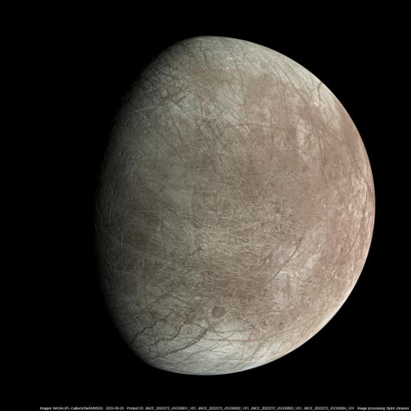 Imagem de Europa, uma das luas de Júpiter, capturada pela câmera JunoCam da sonda Juno. A superfície gelada da lua exibe padrões de rachaduras e tons acinzentados, destacando seu terreno congelado e misterioso.