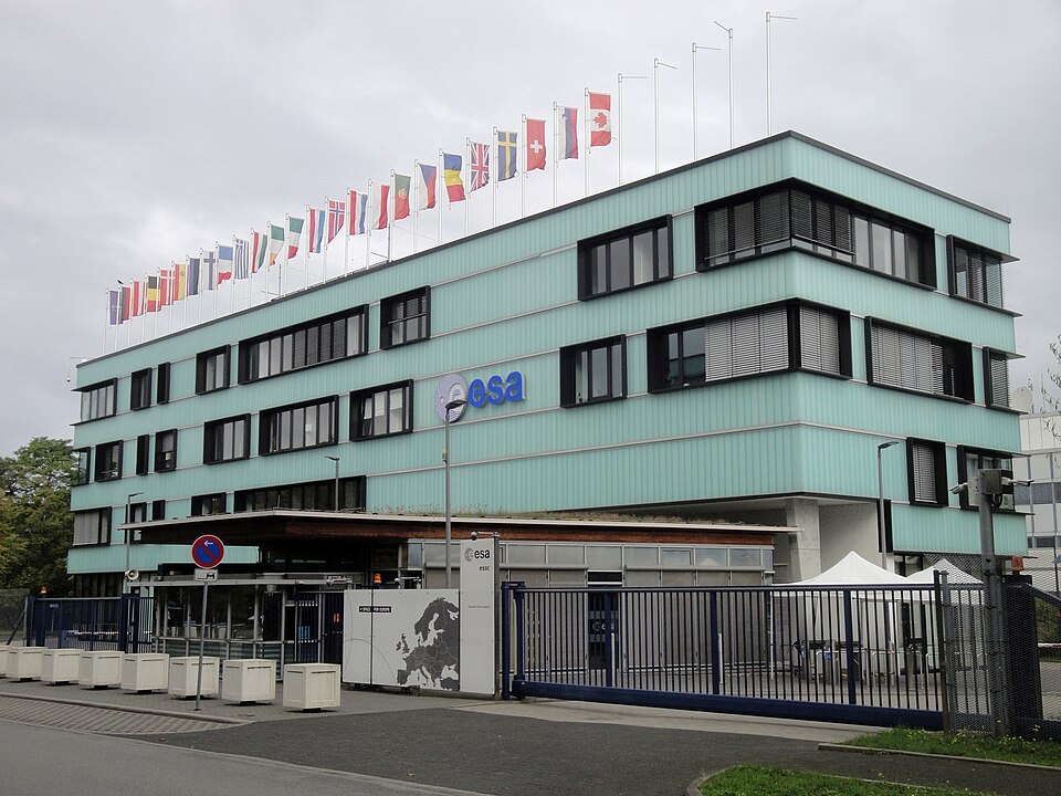 Prédio do European Space Operations Centre (ESOC) da ESA em Darmstadt, Alemanha, com fachada verde claro e bandeiras hasteadas no topo