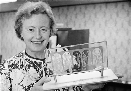 Imagem em preto e branco de Margaret Burbidge, renomada astrônoma, com cabelo curto, sorriso cativante e roupas de época.