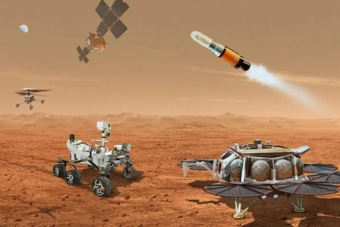 Conceito artístico das missões da NASA em Marte, mostrando o rover Perseverance, o helicóptero Ingenuity, um lançador de amostras e satélites orbitando o planeta, destacando as imagens de Marte NASA.