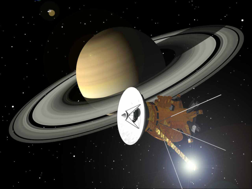 Impressão artística da nave Cassini-Huygens (NASA/ESA/ASI) orbitando Saturno e seus magníficos anéis. O brilho de luz atrás da haste do magnetômetro, na parte inferior da espaçonave, é um reflexo do Sol.