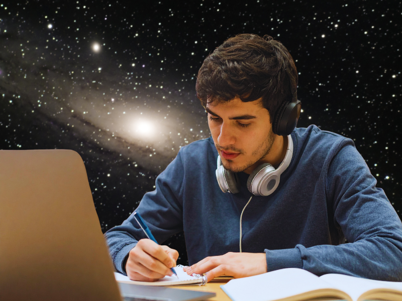 Um jovem sentado em frente a um notebook, usando fones de ouvido, rascunhando anotações enquanto estuda astronomia. Ao fundo, a galáxia de Andrômeda brilha no céu, criando uma atmosfera de aprendizado e exploração espacial