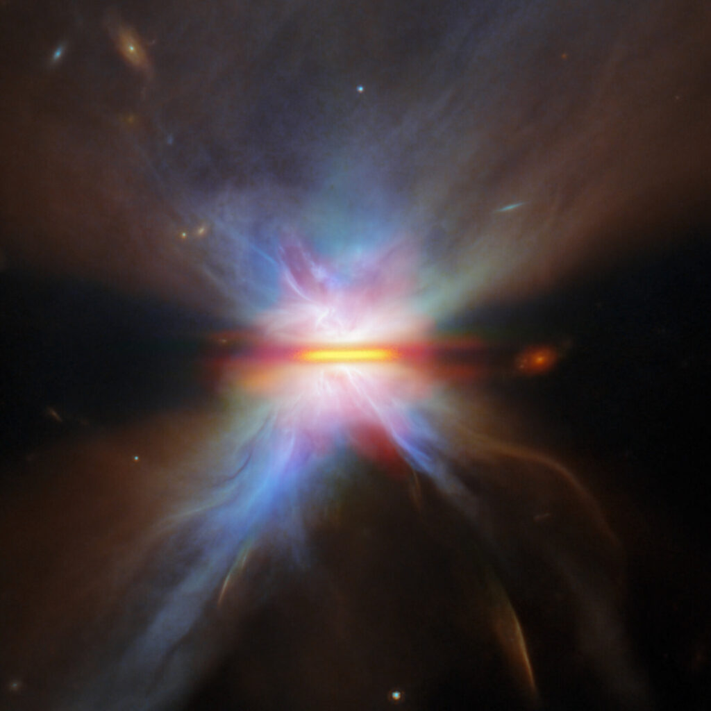 Descrição da imagem: Uma visão detalhada de IRAS 16594-4656 capturada pelo Telescópio Espacial James Webb. Uma região central brilhante é dividida por uma fina linha horizontal de poeira escura. Lobos simétricos de gás luminoso se estendem acima e abaixo, com suaves tons de azul, roxo e laranja se misturando e se dissipando no espaço ao redor.