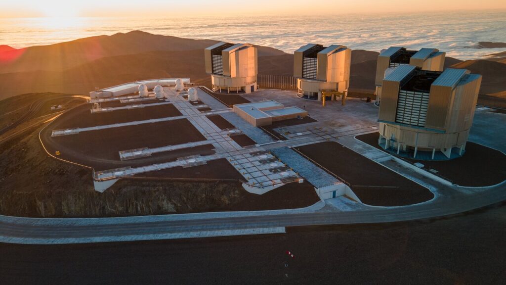O Telescópio VLT da ESO acima das nuvens no Observatório do Paranal, no deserto do Atacama, Chile.Esta imagem mostra os quatro grandes Telescópios Principais e os quatro Telescópios Auxiliares que formam o Very Large Telescope (VLT) do ESO. O Telescópio Principal 1, que começou a operar há 25 anos, está localizado no centro da imagem, ao lado dos Telescópios Auxiliares.