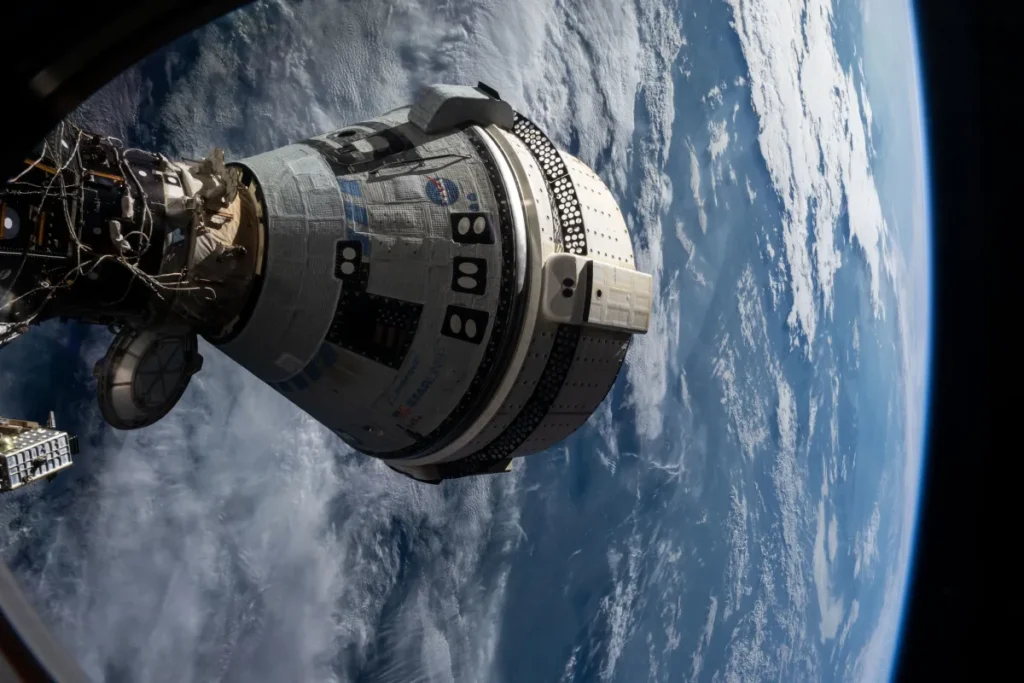 Visão interna da Estação Espacial Internacional mostrando a cápsula CST-100 Starliner da Boeing acoplada, a mesma que apresentou problemas durante sua missão e impediu o retorno seguro de Butch Wilmore e Suni Williams.