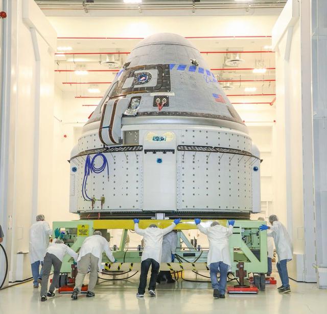 Espaçonave CST-100 Starliner da Boeing em preparação para lançamento dentro do Commercial Crew and Cargo Processing Facility no Kennedy Space Center, Florida, antes de sua missão não tripulada à Estação Espacial Internacional.