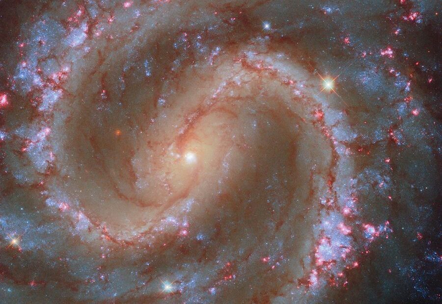 Imagem do Telescópio Espacial Hubble mostrando a galáxia espiral NGC 4535 com seus braços bem definidos e tons azulados e dourados; a galáxia aparece em grande detalhe contra um fundo repleto de estrelas. Crédito: NASA/ESA/Hubble.