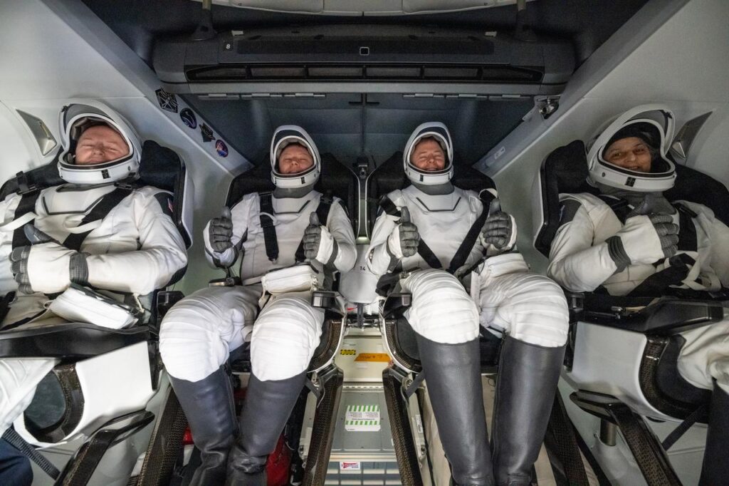 Astronautas Butch Wilmore e Suni Williams, junto com Nick Hague e o cosmonauta Aleksandr Gorbunov, dentro da cápsula SpaceX Dragon logo após o splashdown no oceano, retornando da ISS em março de 2025; Wilmore e Williams originalmente deveriam ter voltado na cápsula CST-100 Starliner, que apresentou problemas.