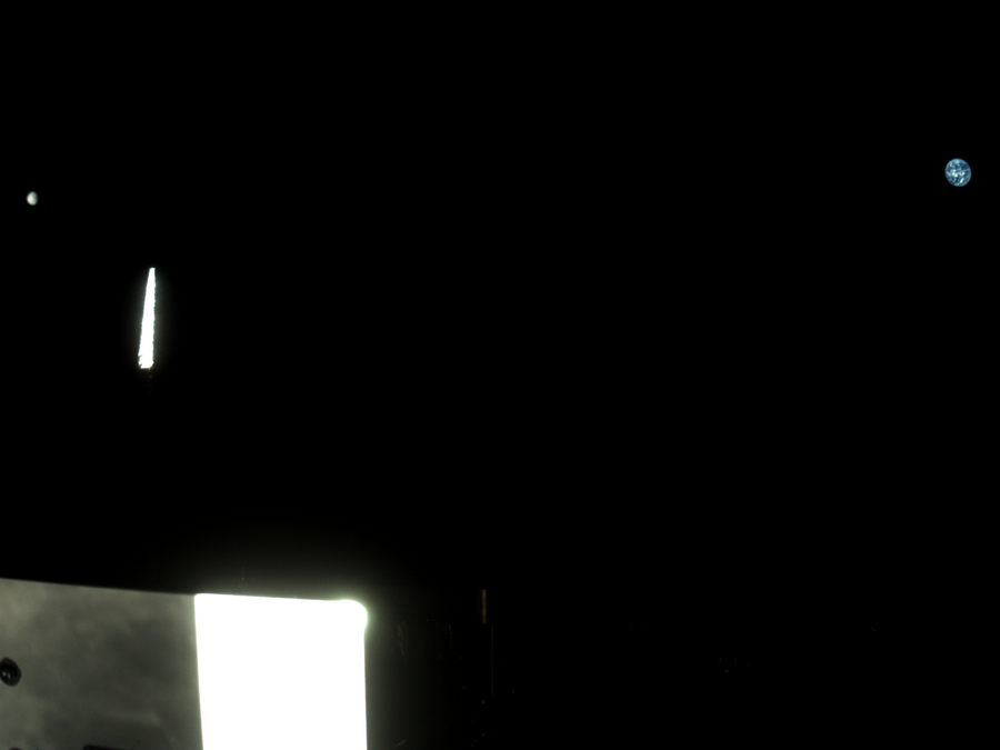 Imagem capturada pela StowCam da missão OSIRIS-APEX mostrando a Lua à esquerda e a Terra à direita, com reflexos dos instrumentos da espaçonave no primeiro plano. A foto foi feita quando a nave estava a cerca de 370 mil milhas de distância da Terra.