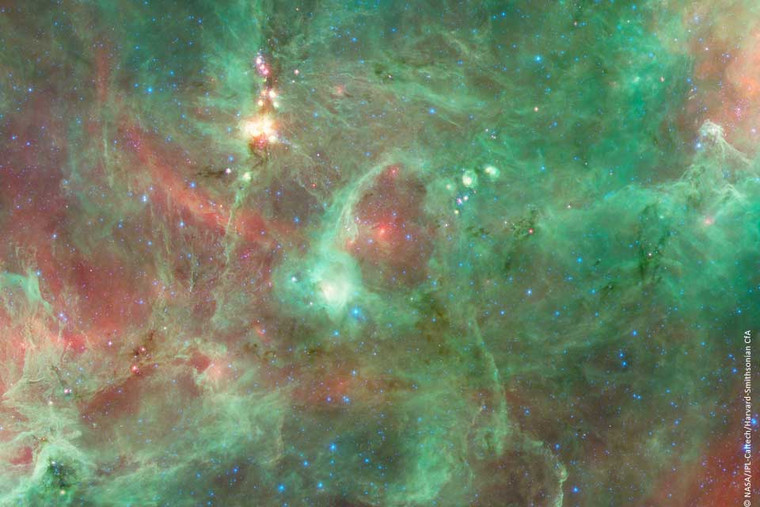 Imagem do Anel Cósmico Cygnus X mostrando uma estrutura elíptica brilhante composta por gás e poeira interestelar, iluminada por estrelas jovens na região de formação estelar Cygnus.