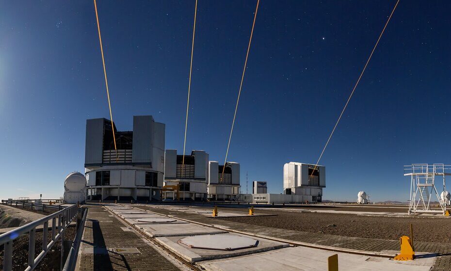 Quatro feixes de laser amarelos são lançados simultaneamente dos telescópios do Observatório de Paranal, no Chile, iluminando o céu noturno como parte do projeto GRAVITY+ do ESO.Créditos: ESO / G. Hüdepohl