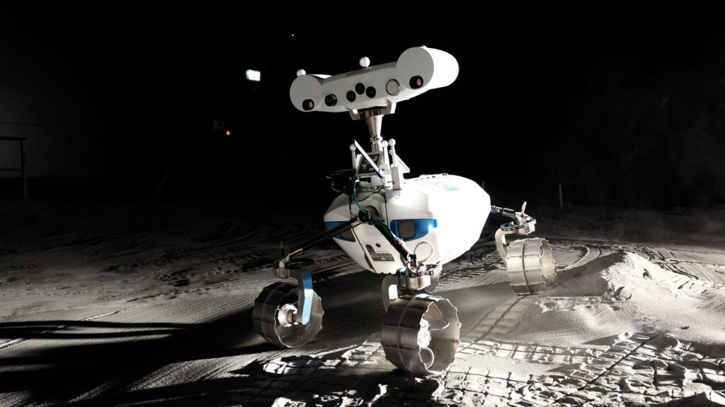 Rover LRU1 usando sua câmera panorâmica estéreo multiespectral para mapear a superfície em 2D e 3D na instalação LUNA, capturando dados além do espectro visível para identificar minerais e apoiar a busca por gelo de água lunar. Crédito: DLR (CC BY-NC-ND 3.0).