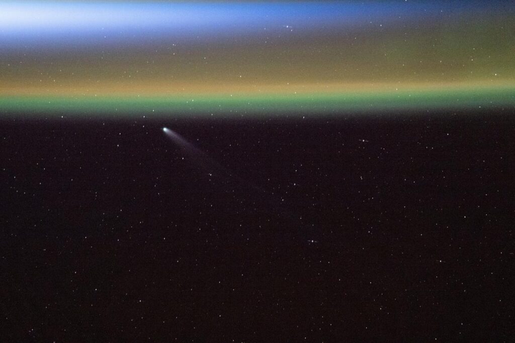 Imagem do Cometa Swan (C/2025 R2) acima do brilho amarelo-esverdeado da atmosfera da Terra, capturado pela Estação Espacial Internacional pouco antes de um nascer do Sol orbital. Foto feita a 264 milhas de altitude sobre o Atlântico, perto de Newfoundland e Labrador. Crédito: NASA/JSC.