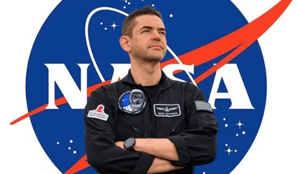 Jared Isaacman posando em frente ao logotipo da NASA após ser