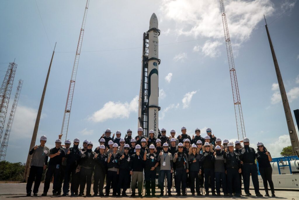Foguete HANBIT-Nano no pad de lançamento do Centro de Lançamento de Alcântara, com a equipe técnica da missão Spaceward posicionada à frente durante os preparativos finais.
