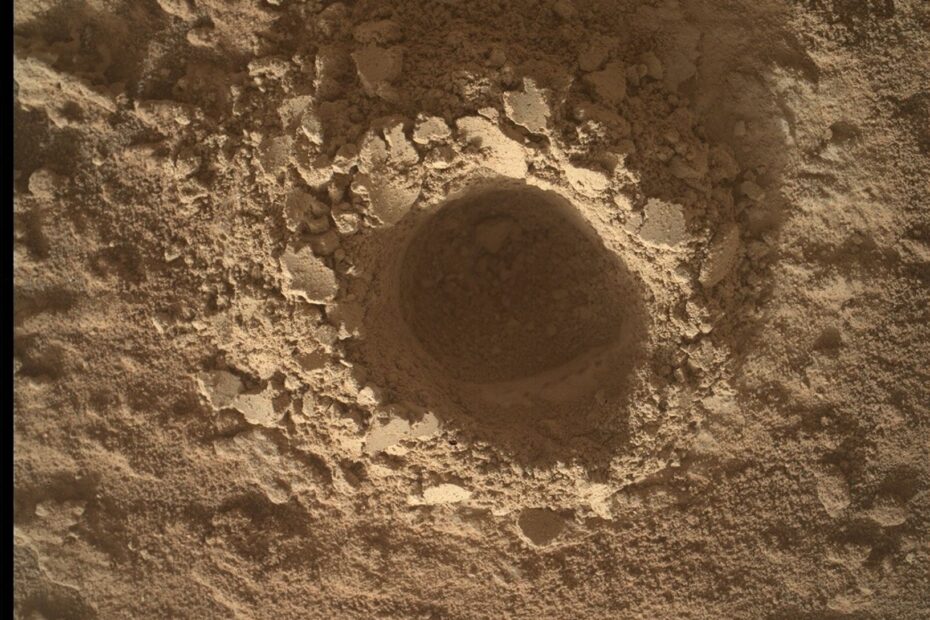 Imagem capturada pelo rover Curiosity em Marte com a câmera MAHLI, mostrando uma visão aproximada da superfície marciana. O enquadramento revela detalhes do solo, incluindo grãos, rachaduras e texturas rochosas em alta resolução. A iluminação destaca as variações de cor e estrutura do terreno, características usadas pela equipe científica para análises geológicas.