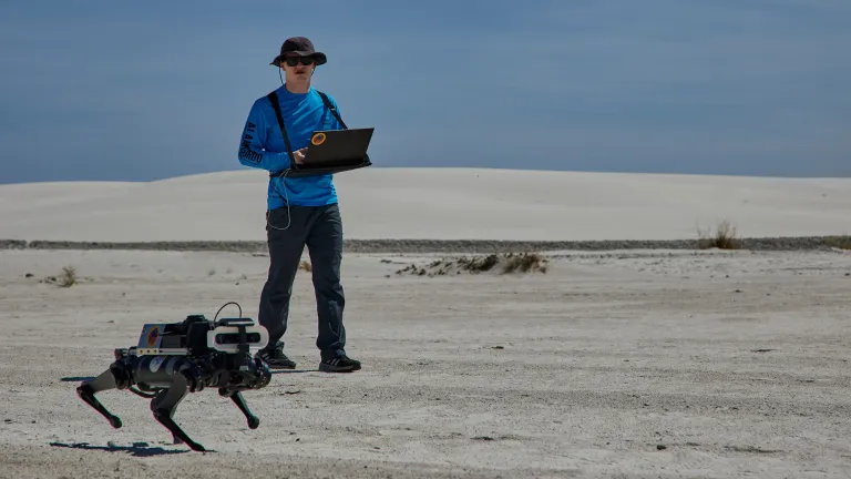 Pesquisador monitora o robô quadrúpede LASSIE-M durante testes no White Sands National Park, no Novo México. O robô está sendo desenvolvido pelo Centro Espacial Johnson da NASA e parceiros para explorar terrenos desafiadores análogos aos de Marte.