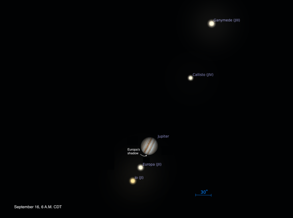 Sombra da lua Europa começando a aparecer no disco de Júpiter, visível na borda leste do planeta durante um trânsito observado às 6h da manhã, com faixas atmosféricas bem definidas.