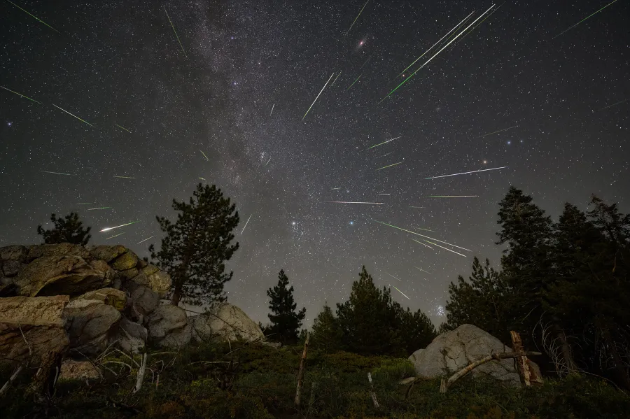 Chuva de meteoros Perseidas iluminando o céu noturno em agosto, com vários meteoros riscando a atmosfera terrestre durante o pico do fenômeno.