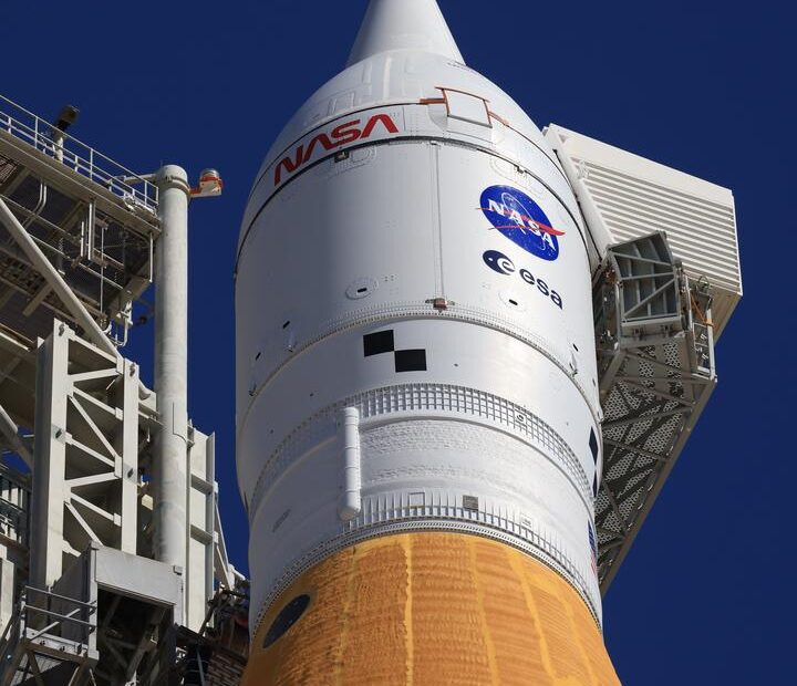 Close-up do foguete SLS da missão Artemis II com a nave Orion e sistema de escape no topo na plataforma 39B do Kennedy Space Center.