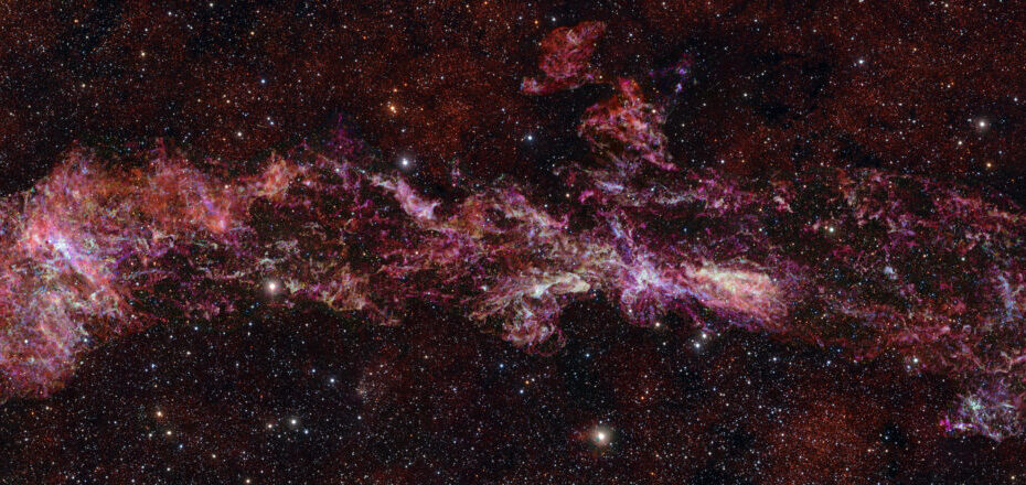 Mapa colorido do núcleo da Via Láctea produzido pelo levantamento ACES com o ALMA, mostrando a distribuição de cinco moléculas em cores diferentes: monóxido de enxofre (ciano), monóxido de silício (verde), ácido isociânico (vermelho), cianoacetileno (azul) e monossulfeto de carbono (magenta). Estrelas em primeiro plano foram registradas em infravermelho pelo telescópio VISTA.