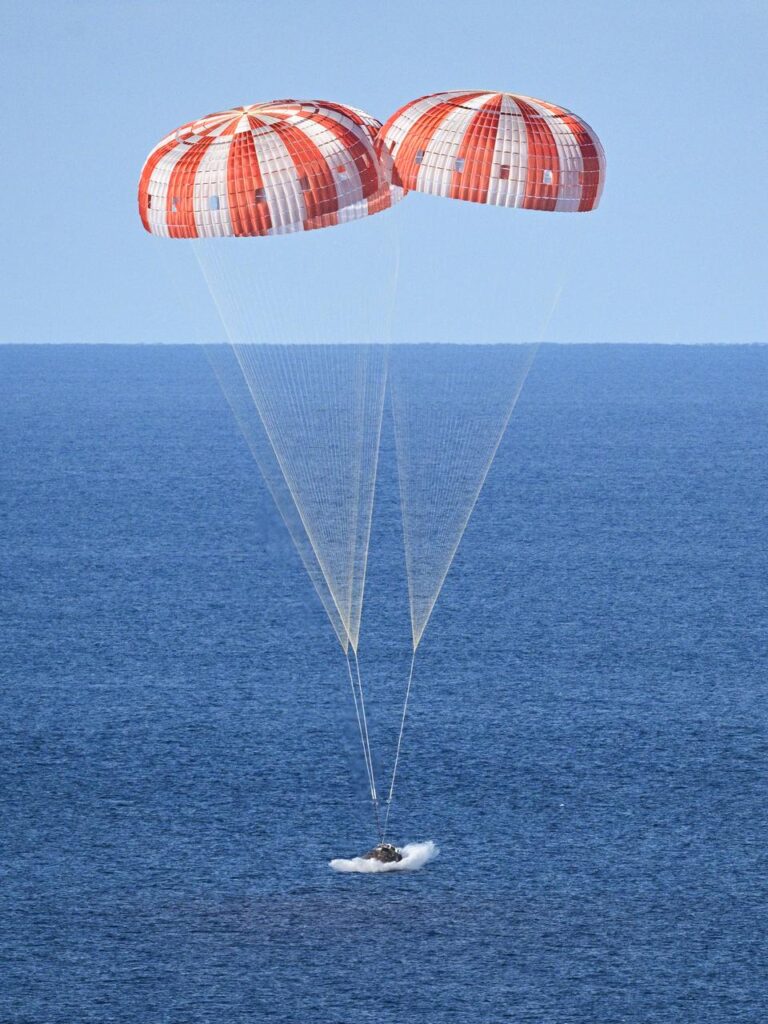 Cápsula Orion da missão Artemis II realizando splashdown no Oceano Pacífico com astronautas a bordo após retorno da Lua