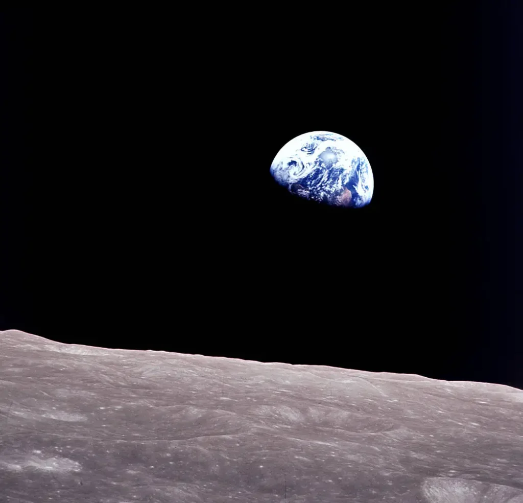 Imagem Earthrise mostrando a Terra surgindo no horizonte da Lua capturada durante a missão Apollo 8 com a superfície lunar em primeiro plano