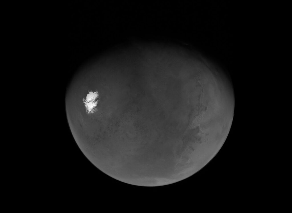 A sonda Psyche da NASA capturou sua primeira visão de um Marte quase completamente iluminado logo após a maior aproximação do planeta em 15 de maio de 2026. A imagem revela desde a calota polar sul até o gigantesco sistema de cânions Valles Marineris, oferecendo uma perspectiva detalhada da superfície marciana. Imagem em tons naturais de Marte capturada pela missão Psyche da NASA mostrando a calota polar sul e o sistema de cânions Valles Marineris após a aproximação do planeta em 2026. Créditos da imagem: NASA/JPL-Caltech/ASU